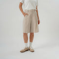 Women wearing beige bermuda pants with modern silhouette for daily wear