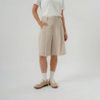 Women wearing beige bermuda pants with modern silhouette for daily wear