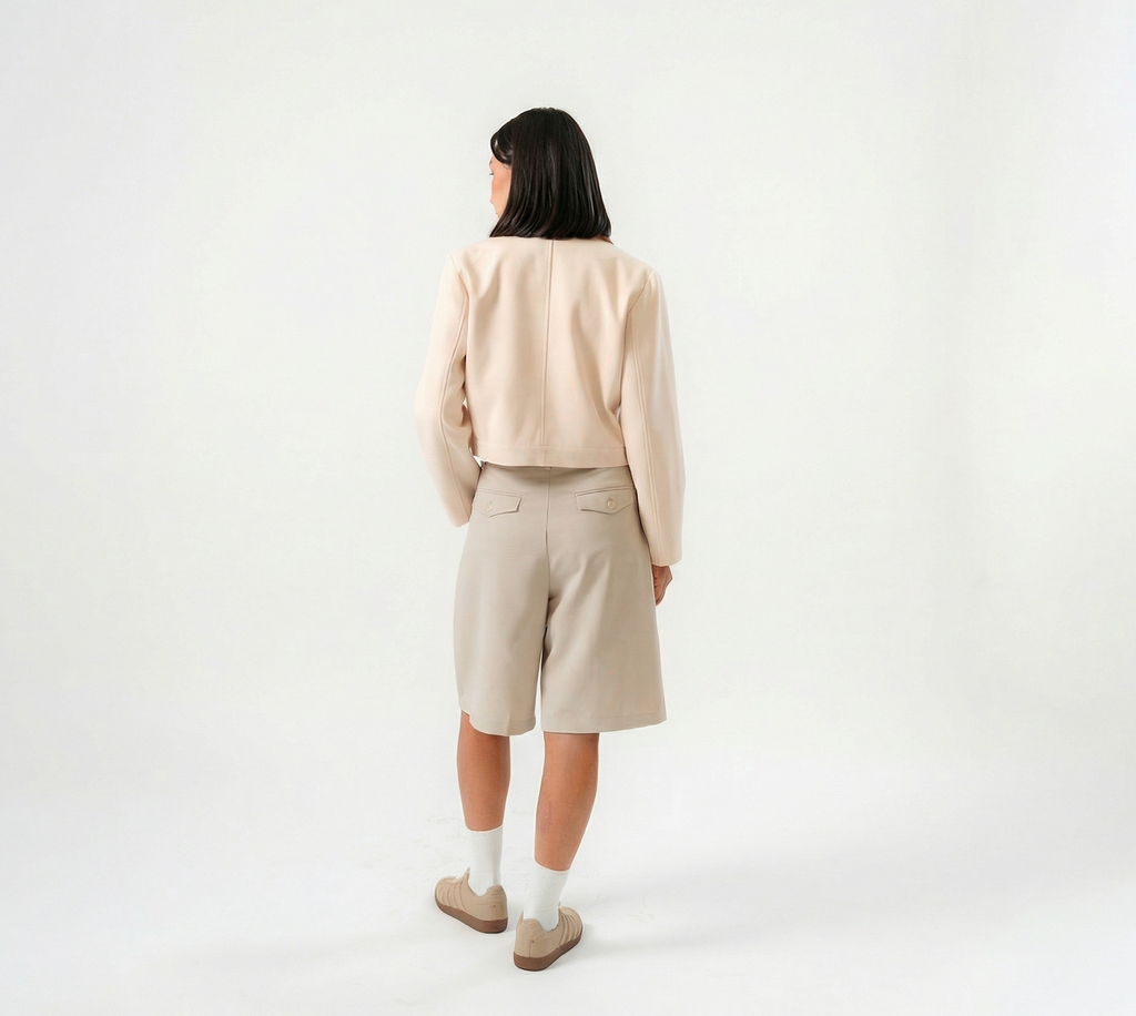 women wearing a beige biker jacket with full zip and bermuda pants with modern silhouette, design for daily city wear