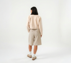 women wearing a beige biker jacket with full zip and bermuda pants with modern silhouette, design for daily city wear