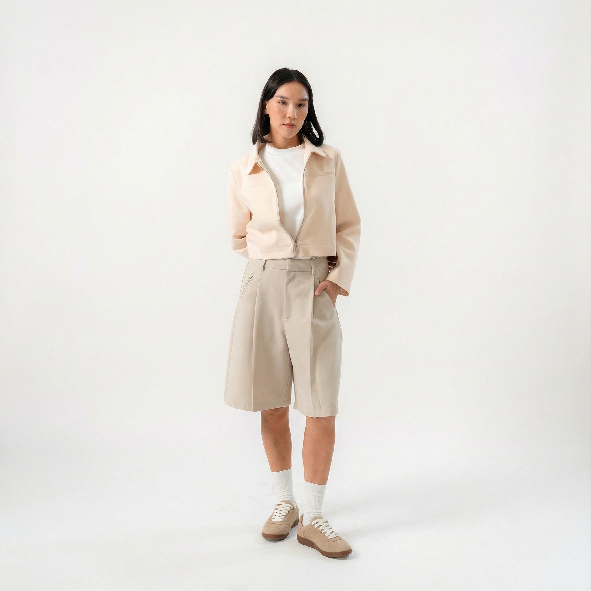 women wearing a beige biker jacket with full zip and bermuda pants with modern silhouette, design for daily city wear