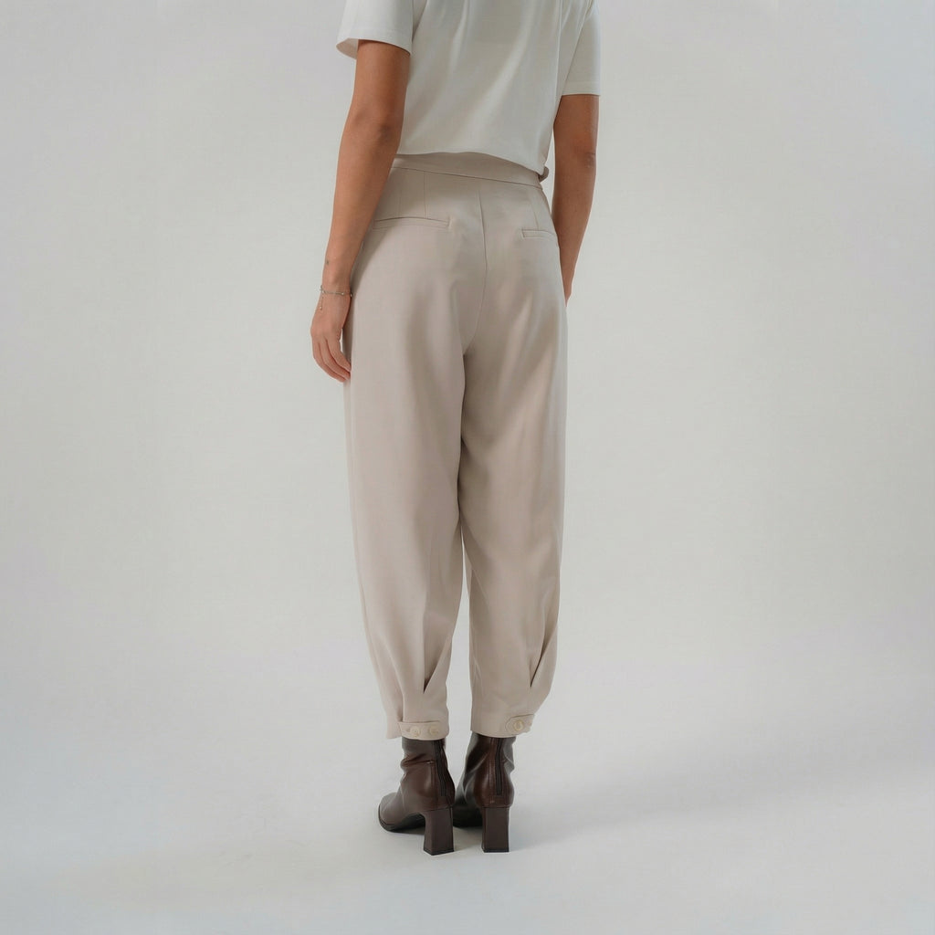beige cross pleated pants with back pocket and button straps at bottom