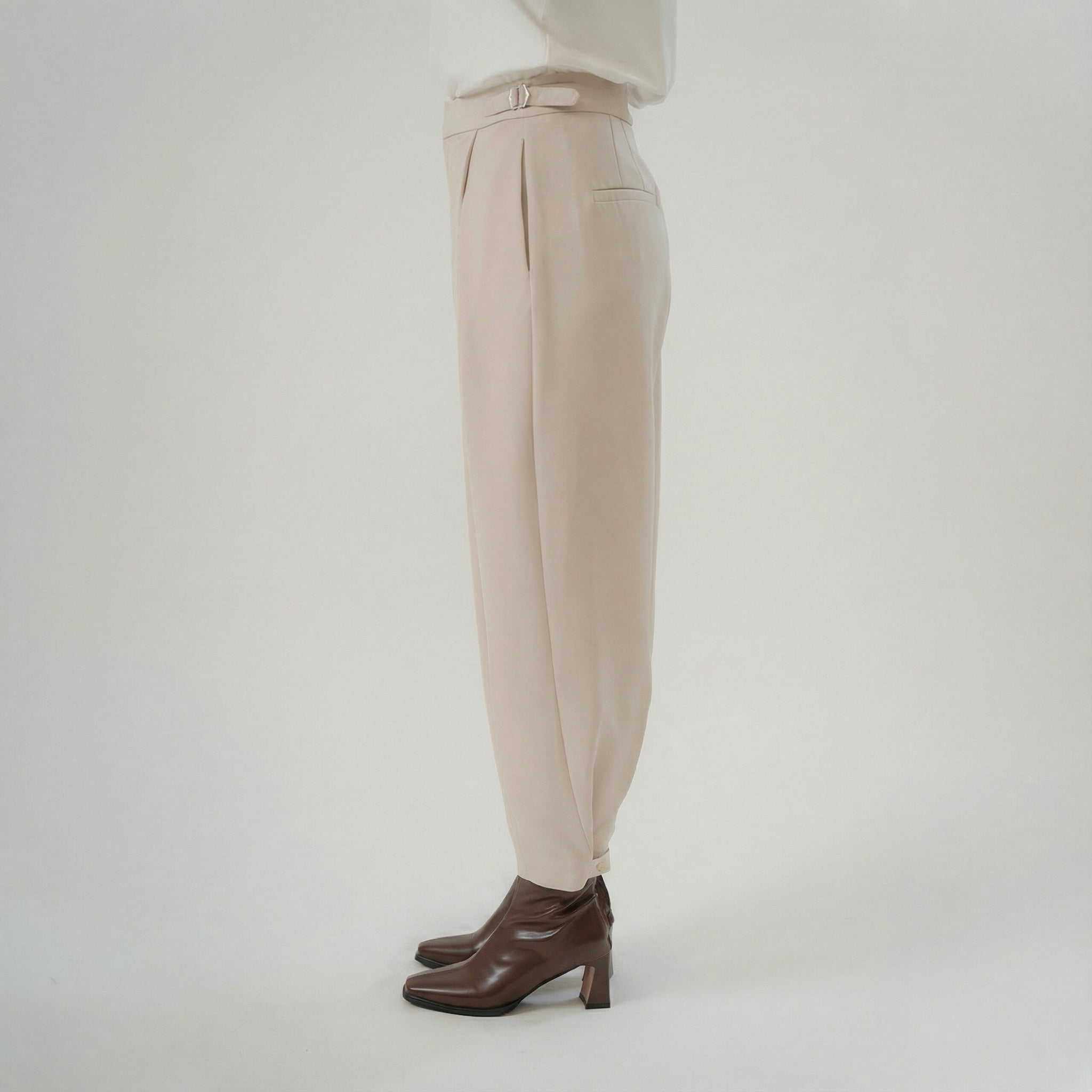 beige cross pleated pants side view with balloon silhouette and modern design