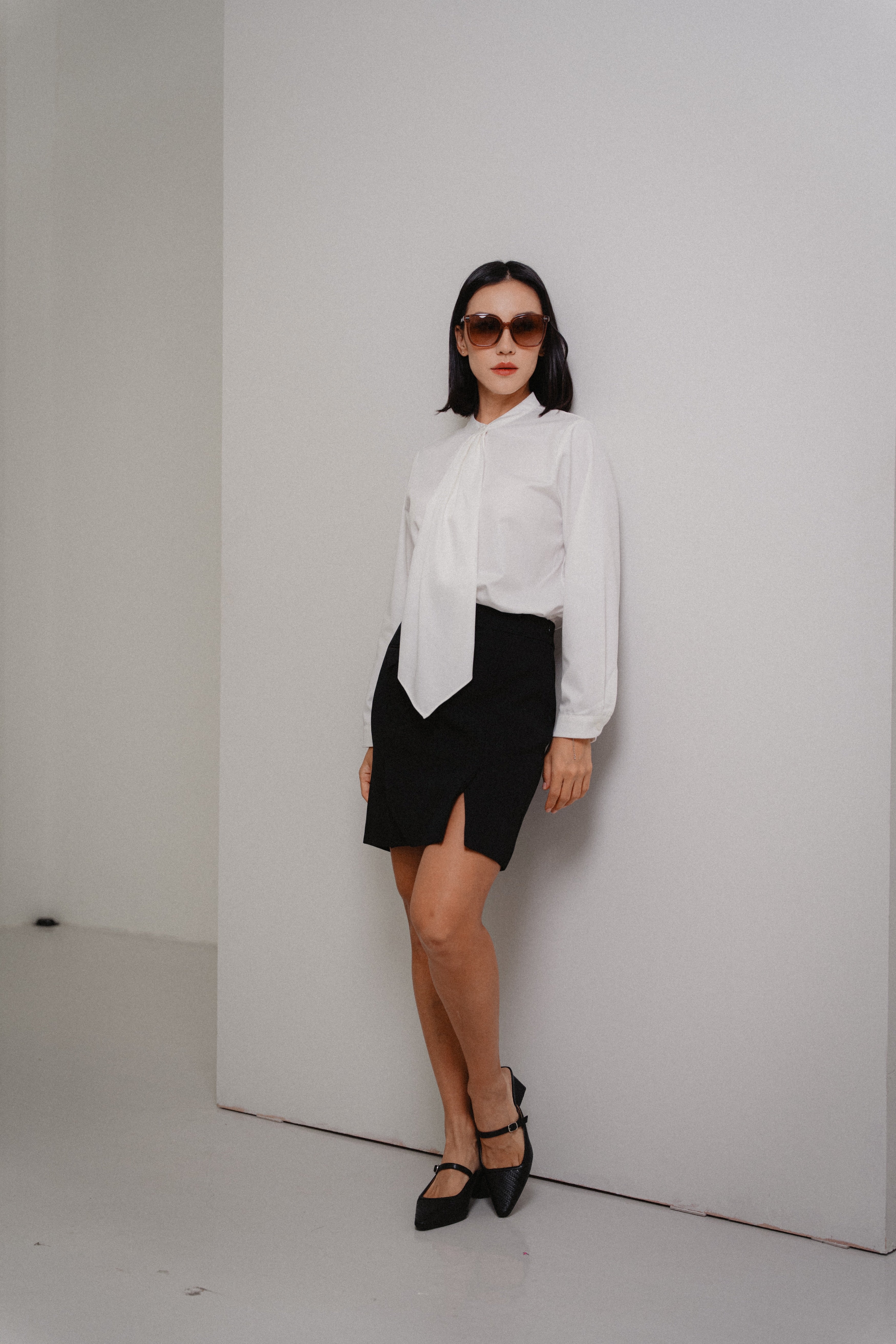 women wearing round collar tie blouse and black mini pencil skirt with front slits, fit style, design for women office and city wear