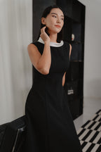 Woman wearing a black sleeveless maxi dress with white boat neck collar design, modern silhouette, perfect for office wear