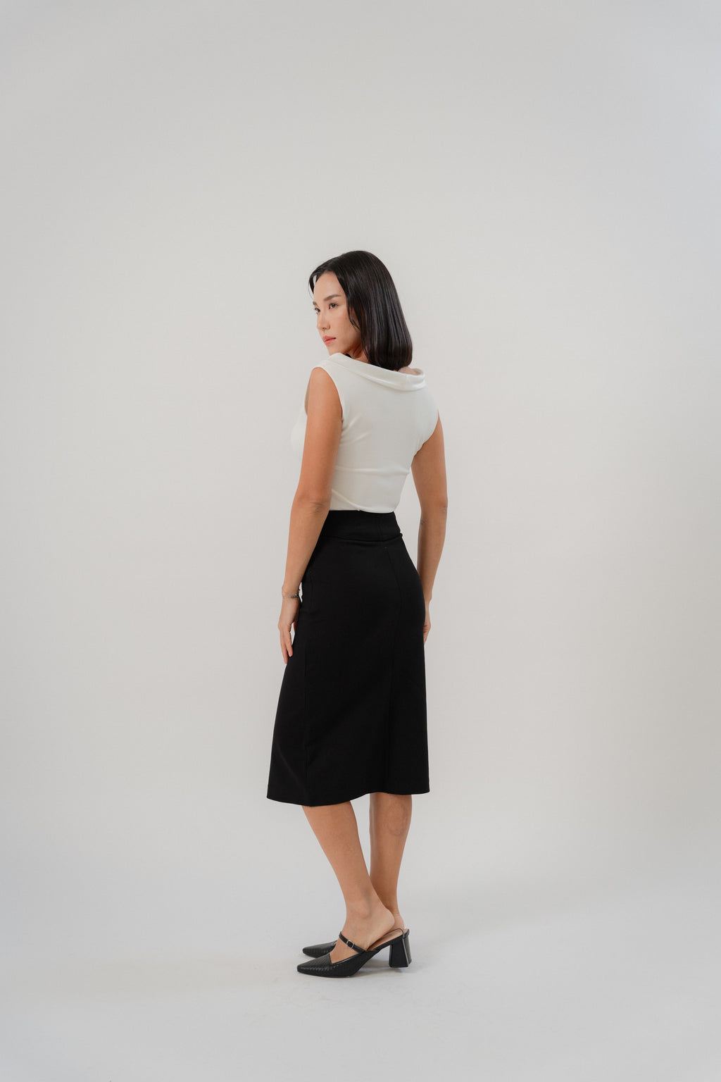 black straight slim skirt with wide waistband, large pleat, pocket square details, design for office and city wear.
