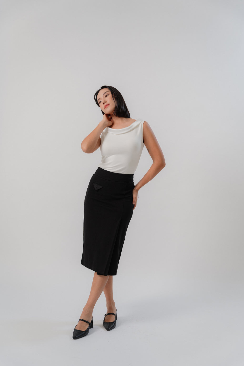 black straight slim skirt with wide waistband, large pleat, pocket square details, design for office and city wear.