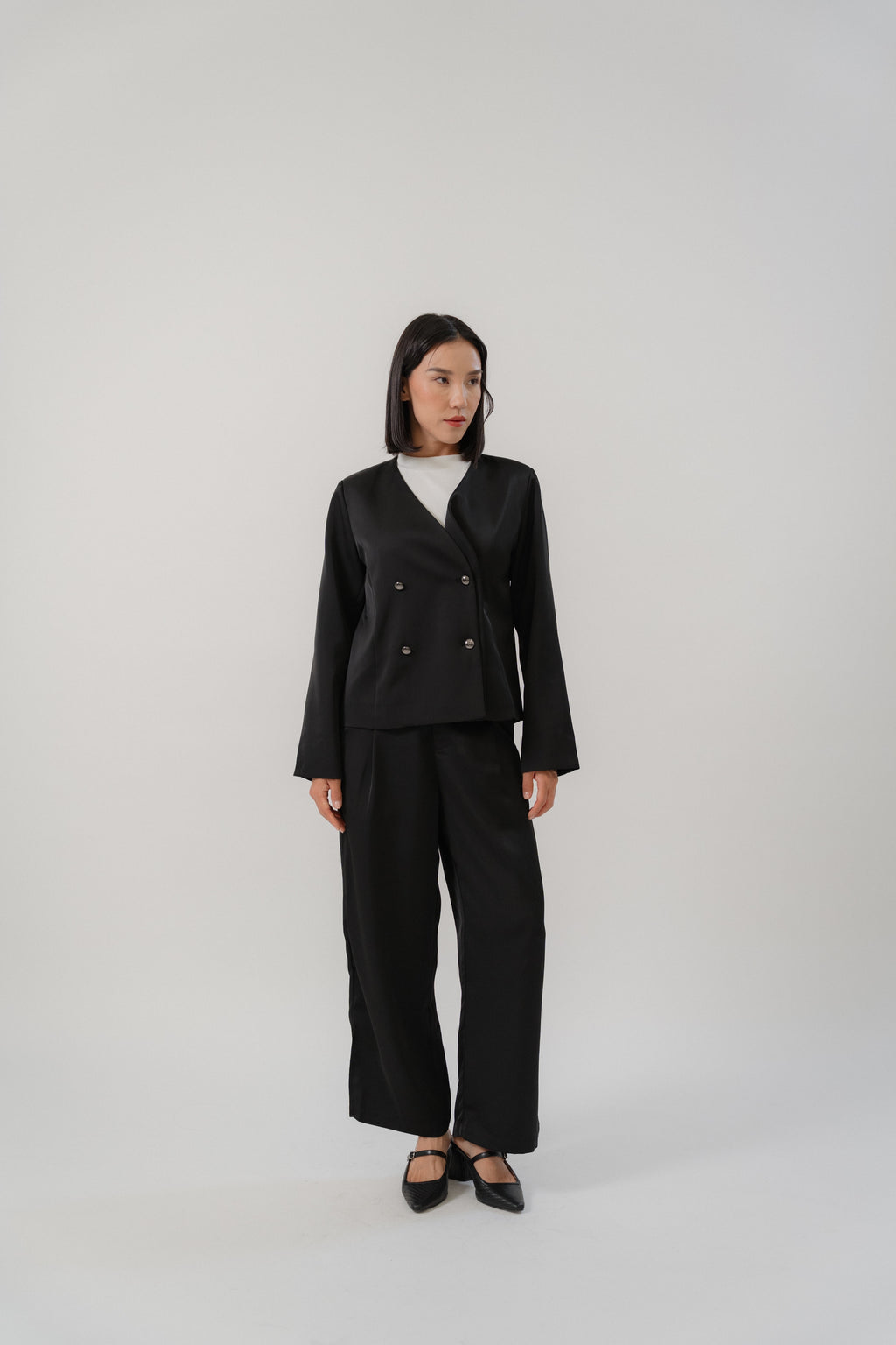 Black tailored blazer and satin pants for women with a modern silhouette, designed for office and city wear.