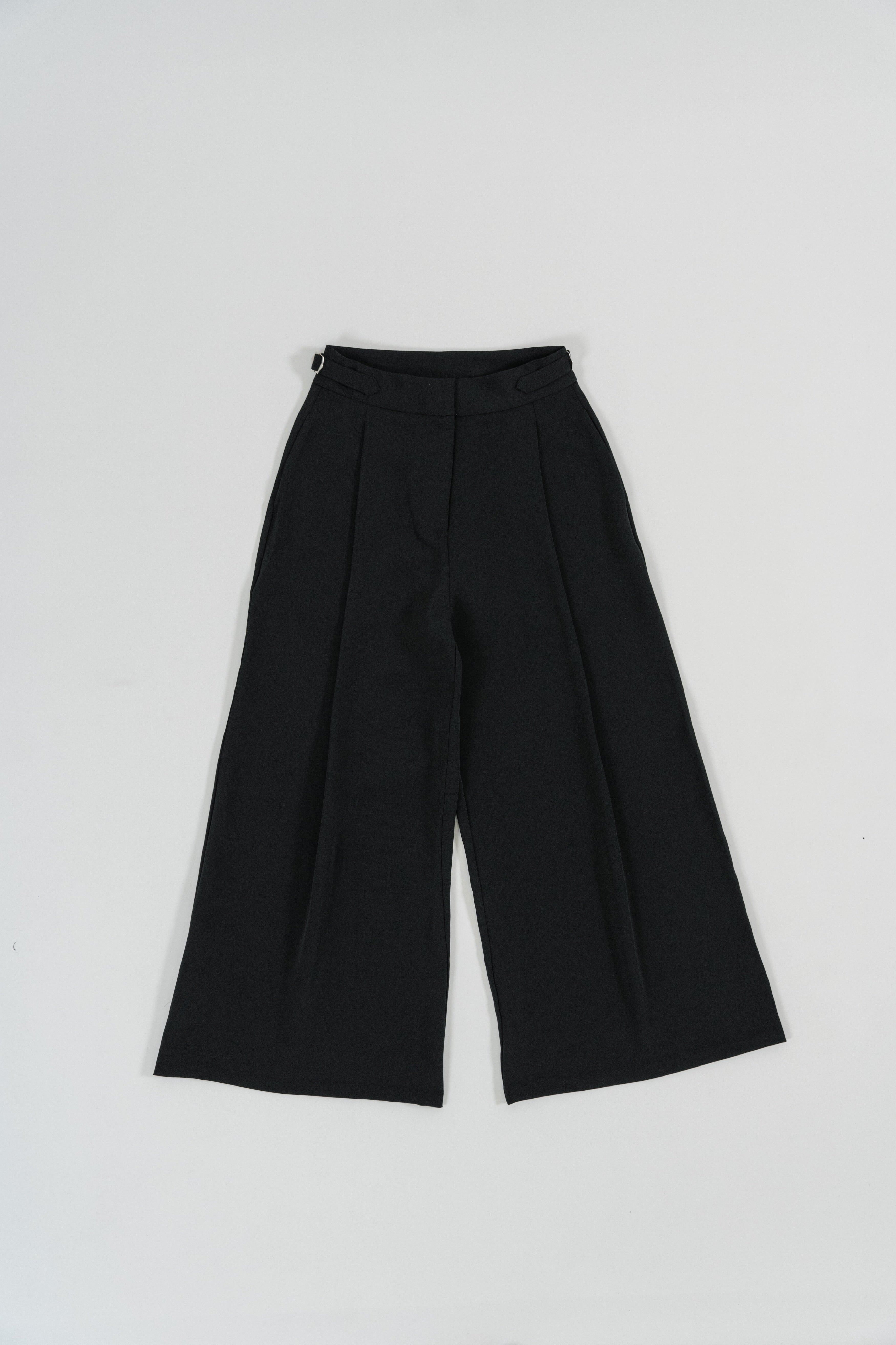 Black wide leg pants with wide leg cut, single front pleat, metal buckle straps, design for office and daily wear.