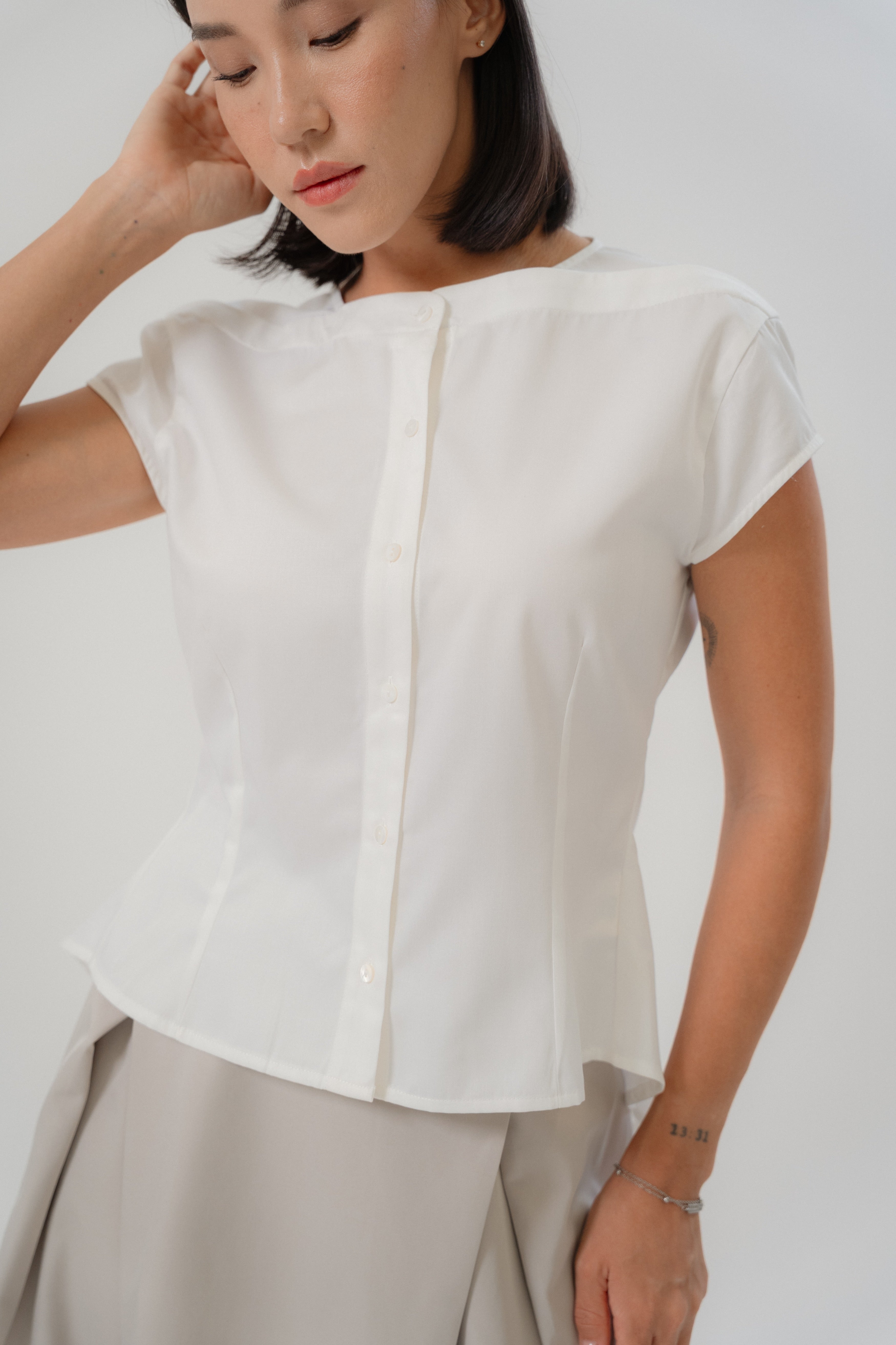 women wearing white capsleeve blouse with back flare, boat neckline, regular fit timeless design, perfect for office and daily wear
