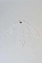 White collared long-tailed blouse with puffy sleeves and a back pleated tail that creates a flowing silhouette, designed for office and city wear.