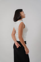 white sleeveless top with boat neckline in satin, comfortable fit, designed for women's office and city wear.