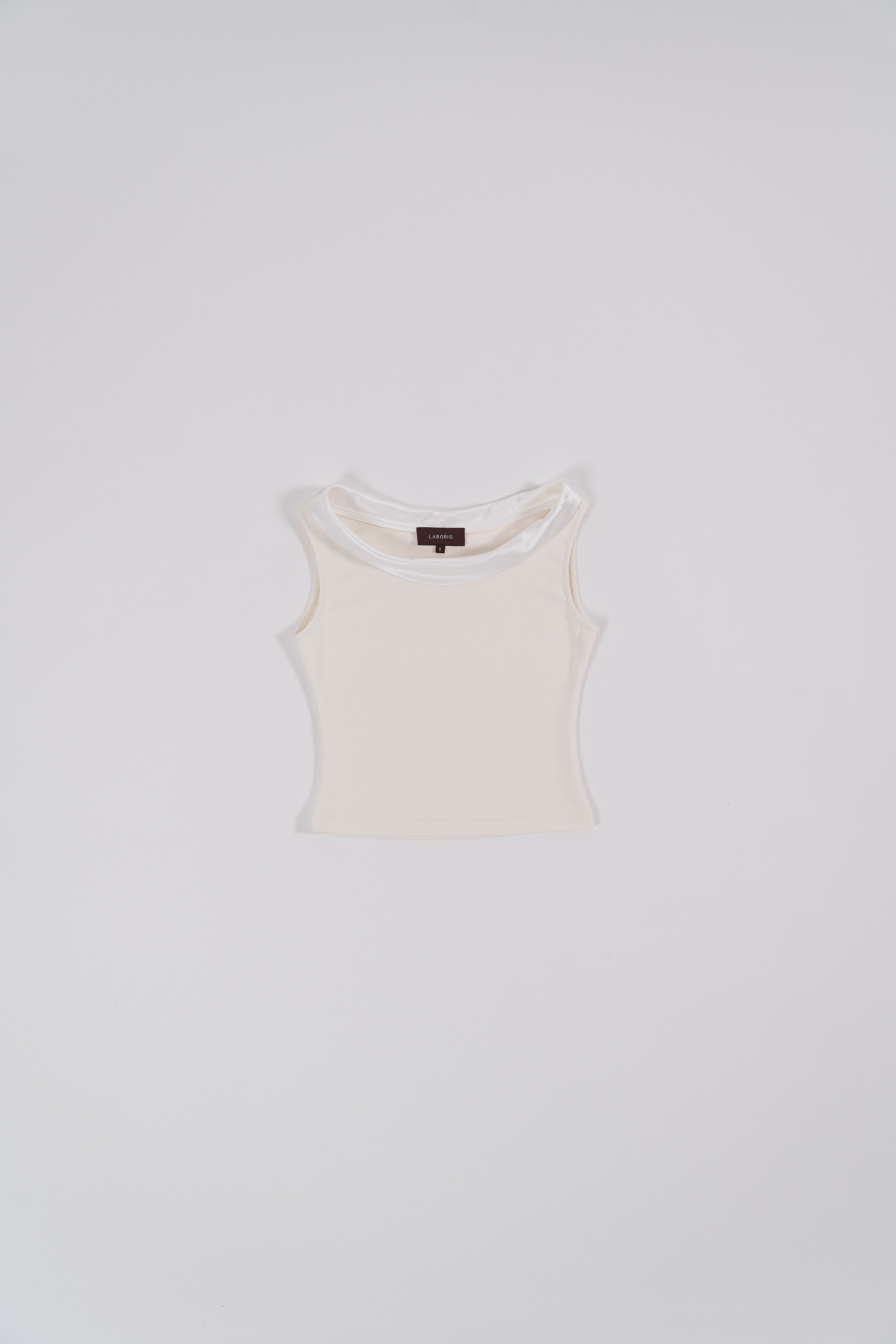 white sleeveless top with boat neckline in satin, comfortable fit, designed for women's office and city wear.