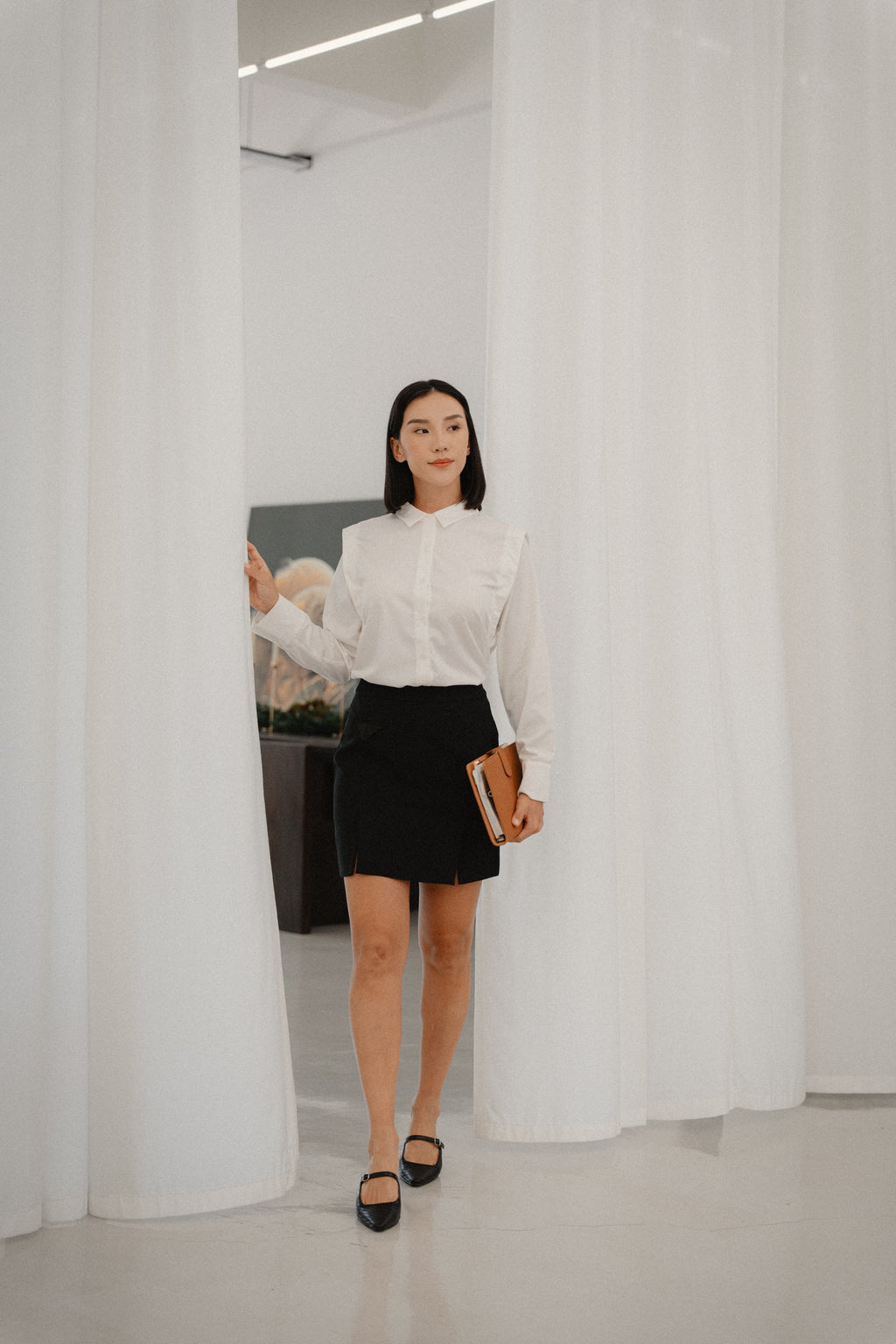 women wearing wide shoulder blouse and black mini pencil skirt with front slits, fit style, design for women office and city wear